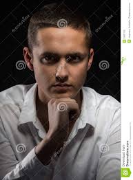 Young composed man with his fist to chin thinking - portrait-young-attractive-man-white-shirt-his-fist-to-chin-thinking-looking-straightforward-29937105