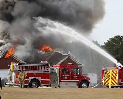 Image of firefighter extinguishing a house fire