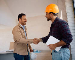 Imagem de happy customer shaking hands with a construction worker