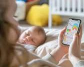 Изображение: happy mother using a smartphone app powered by AI to track her baby's sleep schedule, while the baby sleeps peacefully in a smart crib