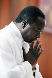 Fr. Patrick Gitonga Nyaga prays during a mass on a recent Saturday at Our Lady of Mount Carmel church in Fairfield. Nyaga has lived in the United States for ... - 29-priest-2-682x1024