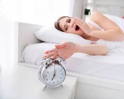 Uyuyan bir kişi ve alarm çalan saat resmi resmi