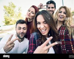 Image of group of friends taking selfies in fashionable outfits