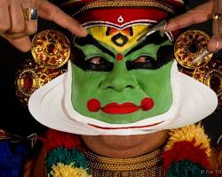 Image of Colorful Kathakali performers with elaborate costumes and makeup, showcasing their expressive movements in a traditional dance performance.