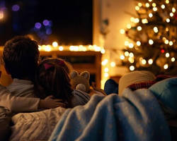 Изображение: family cuddled up on the couch, watching a movie together