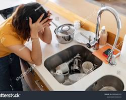Image of person looking frustrated at a sink with no faucet