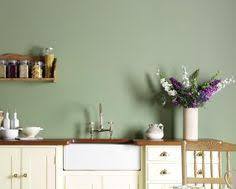 تصویر kitchen with cream cabinets and a green accent wall