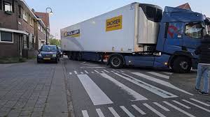 Geparkeerde auto geraakt door vrachtwagentrailer in GouGeparkeerde auto beschadigd door vrachtwagen in Joubertstraat