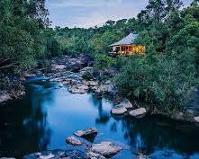 A luxurious tented villa with a private deck overlooking a river at Shinta Mani Wild