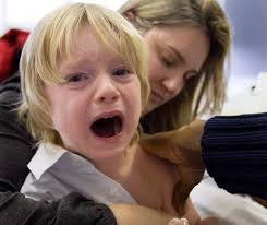 Evan Tordorf, 4, cries as he gets his flu shot as his mother and Karen Joly looks on at a H1N1 vaccination centre in 2009 in Montreal. - CPT117041797_high