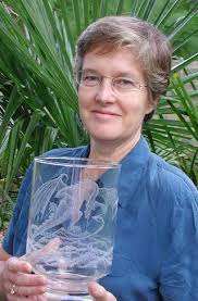 Sue Burne Posing with one of her engraved glass works. Image courtesy of Peter Burne - sburne3