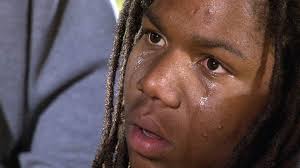 View full size Malcolm X. Shabazz player Wesley Ellis cries while listening to coach Darnell Grant as he talks to his team on the field after their 20-14 ... - shabazzjpg-2d5381831ef4e65e