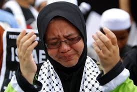 Dua orang pemuda mengibarkan bendera Palestina saat berunjuk rasa mengutuk serangan Israel terhadap warga sipil Gaza - seorang-pengunjuk-rasa-berdoa-sambil-menangis-saat-berunjuk-rasa-_121116161246-959