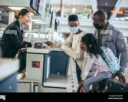 airline staff checking a passport at a checkin counterの画像