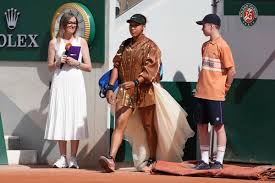 Osaka adds an ivory train and gold bomber jacket to her fashion ensemble at the French Open