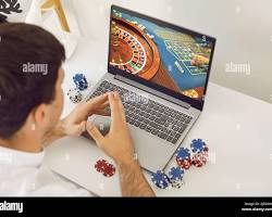 person playing online casino games on a laptop resmi