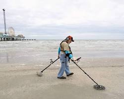 Image of someone metal detecting on a beach