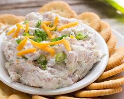 Cream cheese, cheddar cheese, and green onion in a bowl