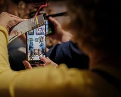 Изображение: person taking a virtual tour of a museum on their smartphone