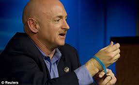 Honour: Kelly shows a silicon wristband honouring his wife and victims of the Arizona shooting that features a heart, a peace sign and the word &#39;Gabby&#39; - article-1358218-0D0C1908000005DC-500_468x286