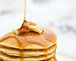 Gambar Serabi Notosuman, a thin pancake with a slightly browned edge, stacked on a plate.