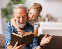 Imagen de elderly person reading to a child