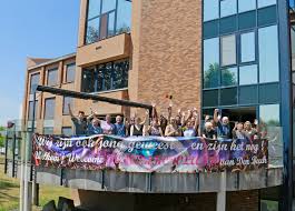 Bewoners woonzorgcentrum Den Beuk begroeten met spandoek de Tomorrowland-gangers