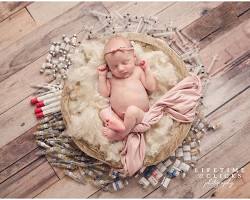 newborn in a photoshoot surrounded by cute props