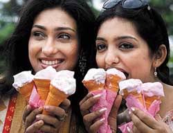 Popular Bengali actress Rituparna Segupta (L) and actress June Malia (R) hold ice-cream cones before an ice-cream eating competition in Kolkata on Sunday. - nat