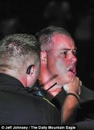 Cullman defensive coordinator Matt Hopper is restrained by police officers following a brawl on the field following Friday night&#39;s Walker-Cullman game - article-2409412-1B96E2E7000005DC-246_306x423