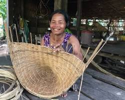 Hands of an artisan skillfully weaving a bamboo basket in Cambodia.