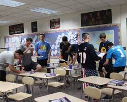 Image of group of students working on a group project, looking stressed