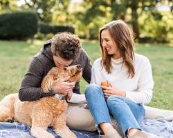 couple cuddling under a blanket with their pet's photoの画像