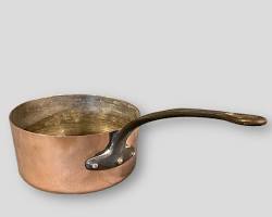 Image of shiny copper pan next to a brass ladle