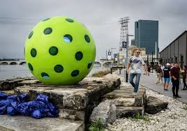 30 times larger than life, a glass pickleball sculpture serves the riverfront