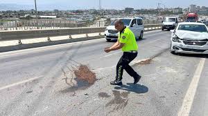Trafik güvenliğini sağlamak amacıyla yağ dökülen yola avuçlarıyla kum taşıyan polis takdir topladı İhlas Haber Ajansı — İhlas Haber Ajansı