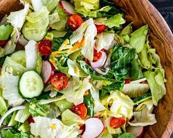 Gambar Tossing salad with dressing