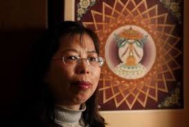 Artist Lily Chang is shown here with one of her pieces, &quot;The Buddha Stupa Mandala,&quot; which was displayed at the Everett Public Library. - everett