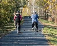 Image of older person confidently cycling through a park
