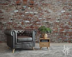 Image of Rustic bedroom with brick wallpaper and leather chair