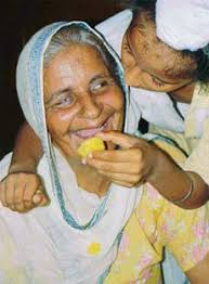 Thrilled with joy Sukhdev&#39;s mother Gurdev Kaur is offered a ladoo by her grandnephew after the news of Sukhdev&#39;s release was received at Makdona village in ... - ind8